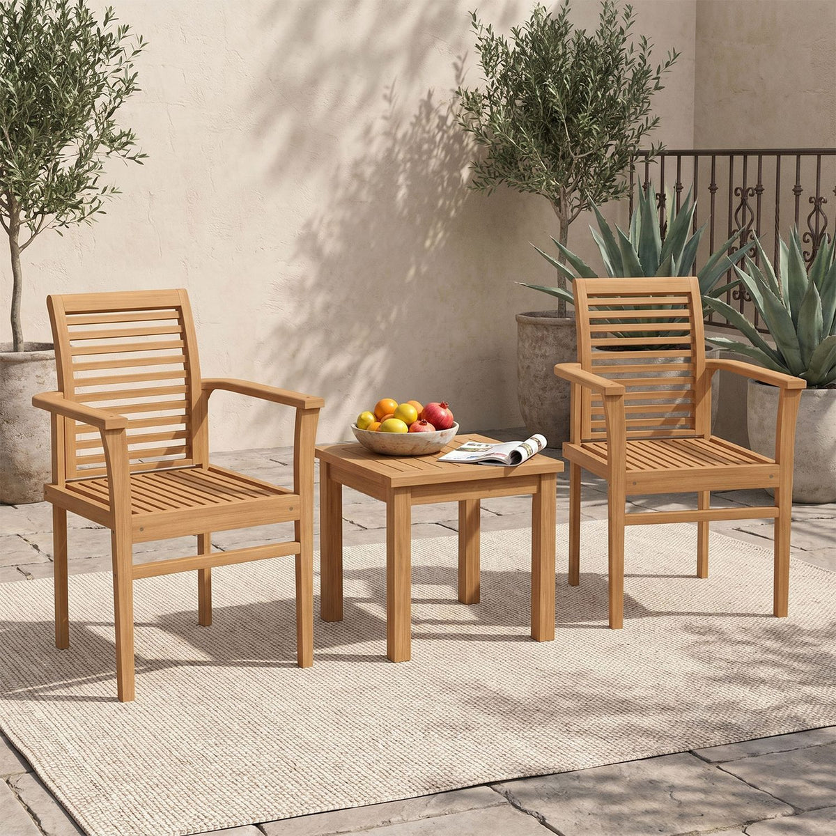 Two wooden slat-back armchairs flank a small table on a sunlit outdoor patio.