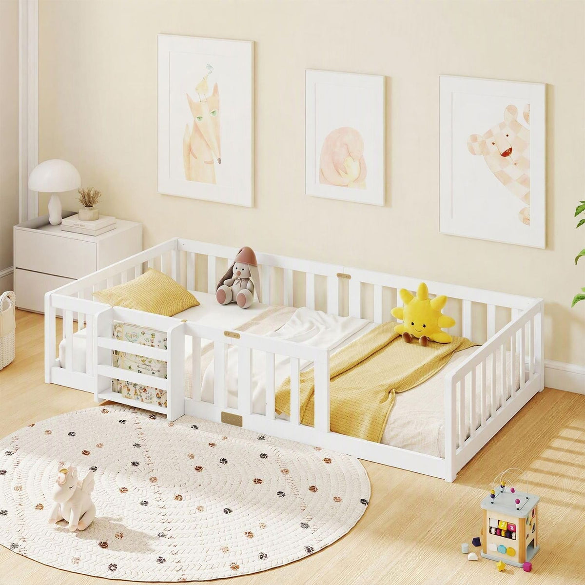 White floor bed with safety rails and a side bookshelf, styled with yellow bedding and toys in a nursery.