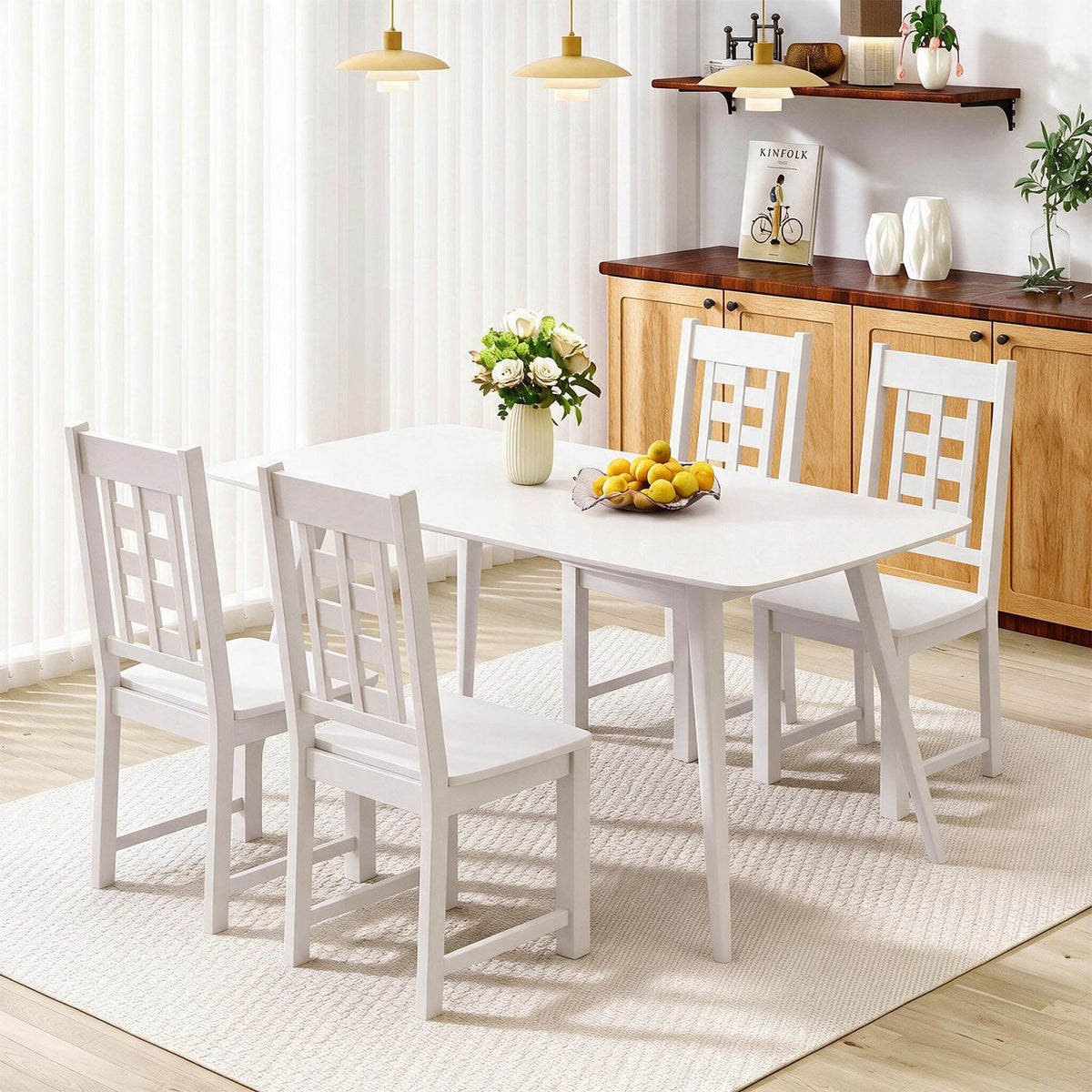 White dining chairs around a rectangular table beside a wooden sideboard