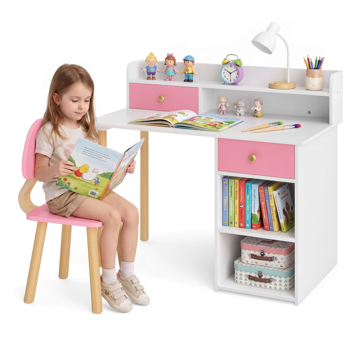 A child reads at a white desk with pink drawers, a matching chair, hutch, books and toys.
