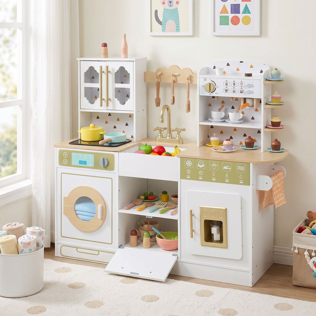 White play kitchen in a bright playroom, with its lower center compartment open and toy food on display.