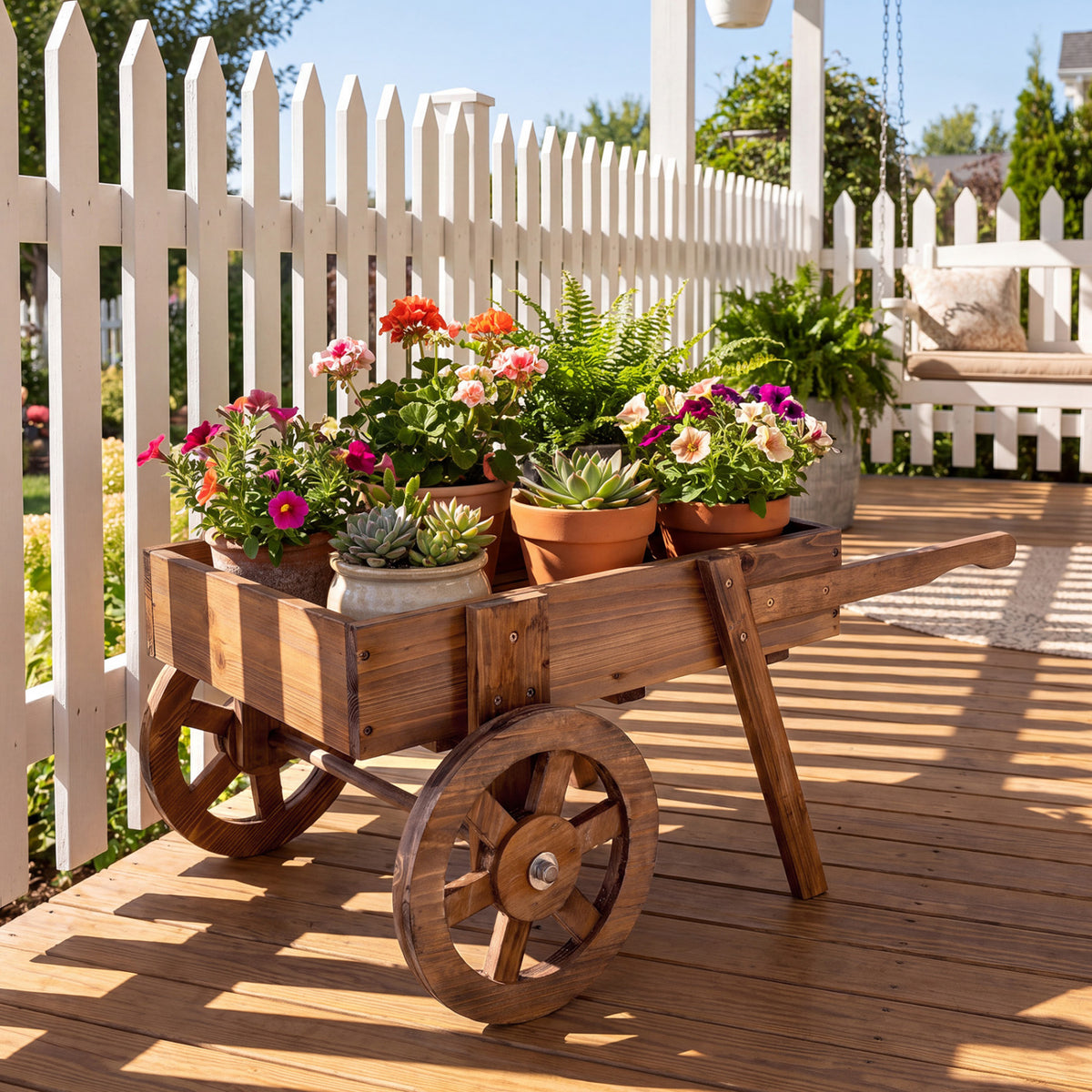 Wooden wagon planter with flowers on a sunny deck by a white fence