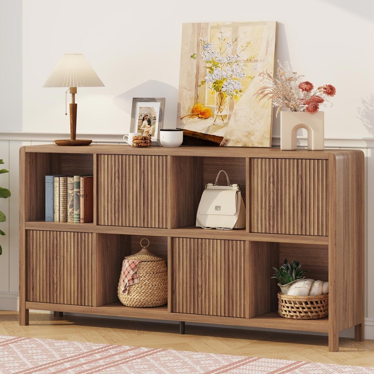Walnut 8-cube shelf with ribbed sliding doors and decorative items on top and in cubbies.
