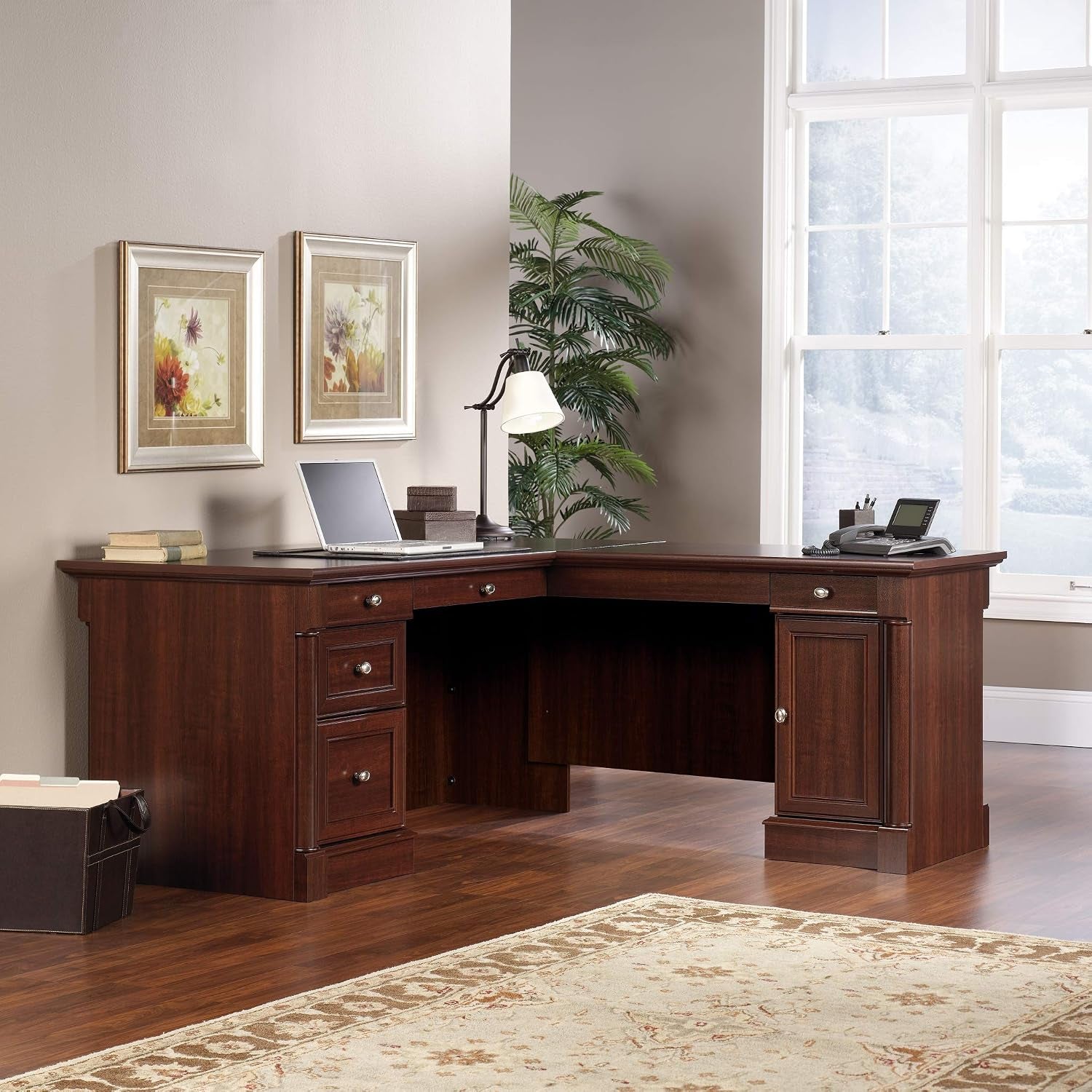 Dark cherry L-shaped desk in a room setting with laptop on the left work surface, angled view