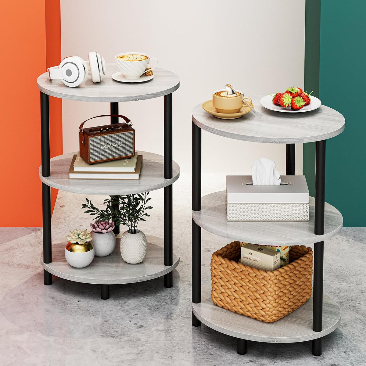 Two three-tier round end tables in light gray wood finish staged with headphones, cups, plants and a woven basket