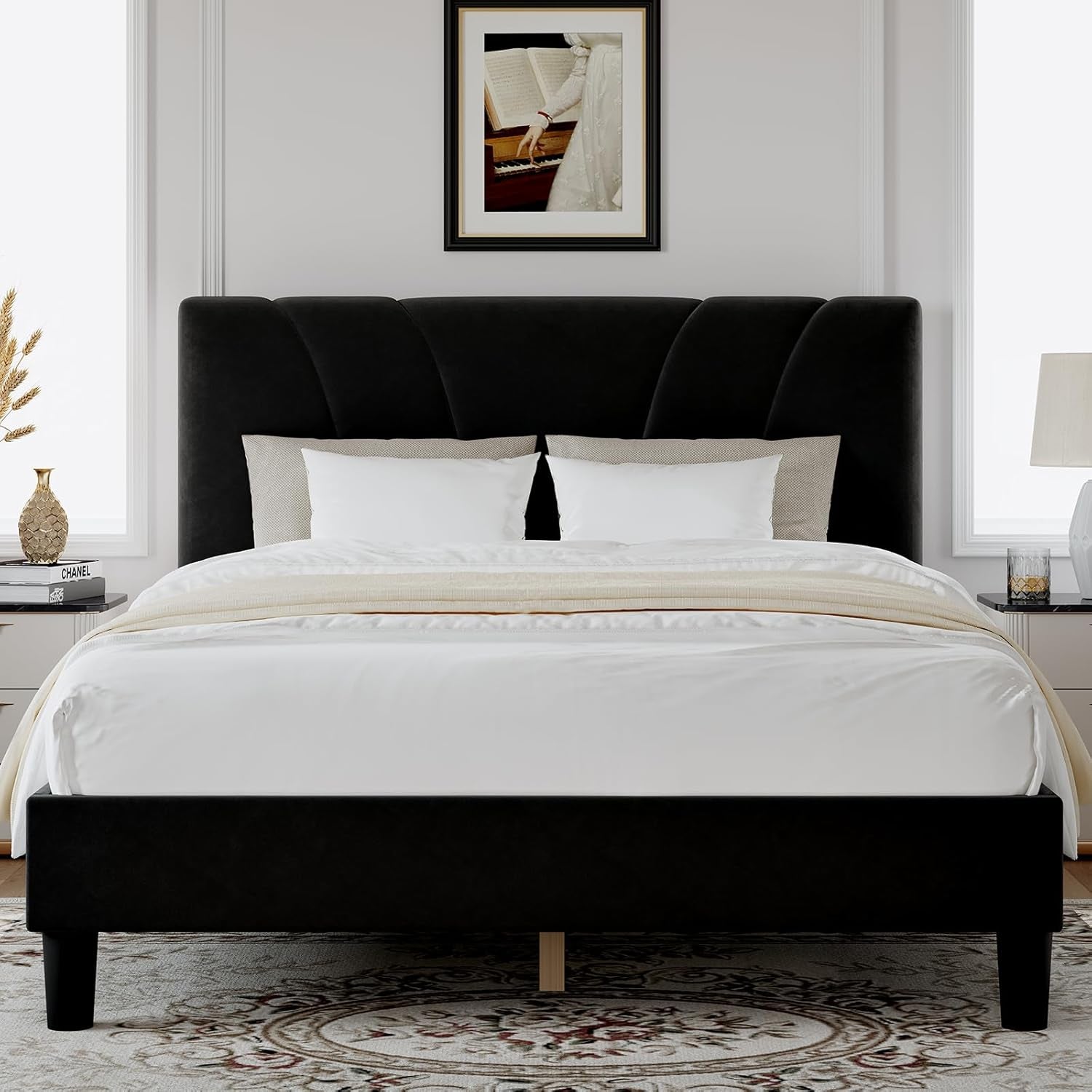 Front view of a black upholstered bed with a fan-pattern headboard and white bedding.