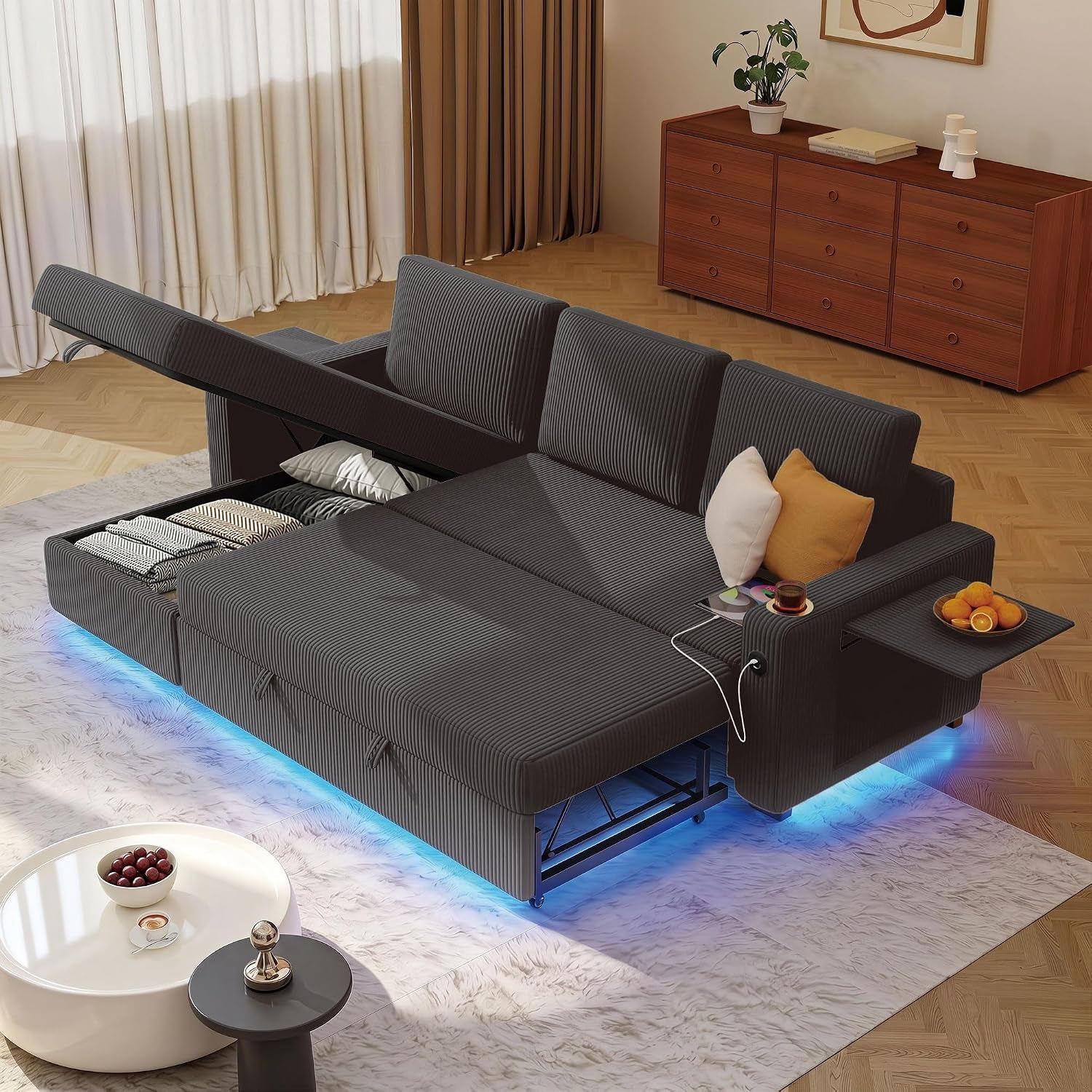 Dark gray corduroy sectional unfolded into a bed with storage open and blue LED lighting underneath.