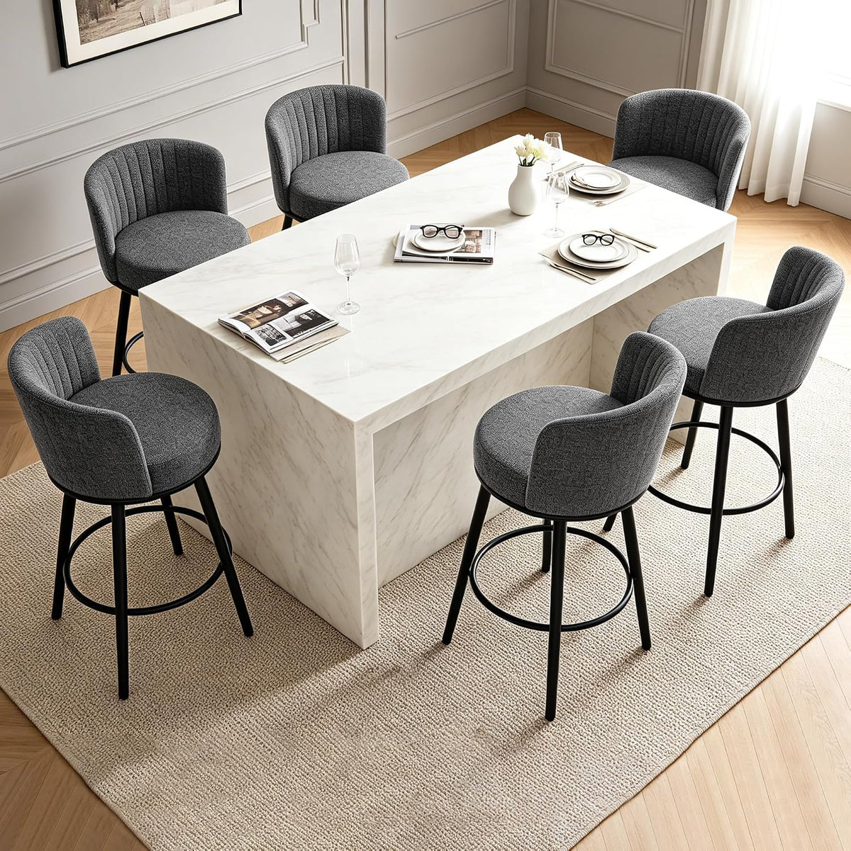 Overhead angled view of six dark gray swivel bar stools arranged around a rectangular white island.