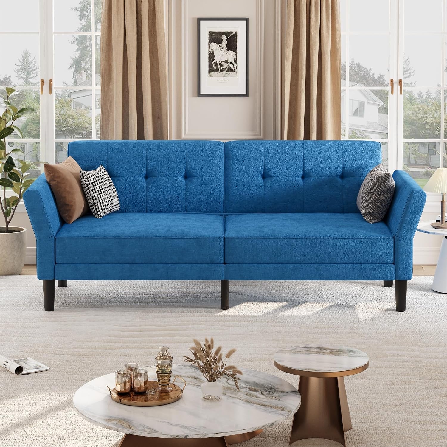 Front view of a blue three-seat futon sofa with angled armrests and two accent pillows