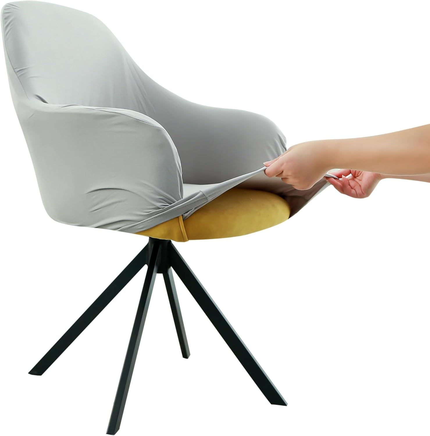 Side view of a swivel armchair with a plain light gray stretch cover being stretched over the seat by hands.