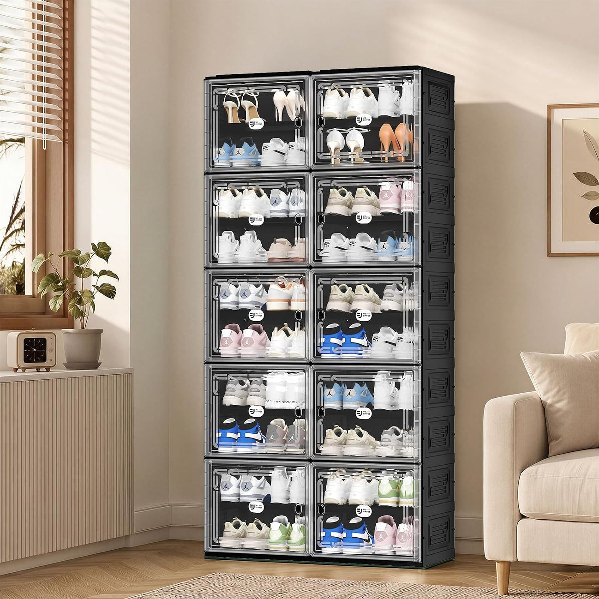 Angled view of a stacked shoe organizer with transparent doors displayed in a living room next to a sofa and window.