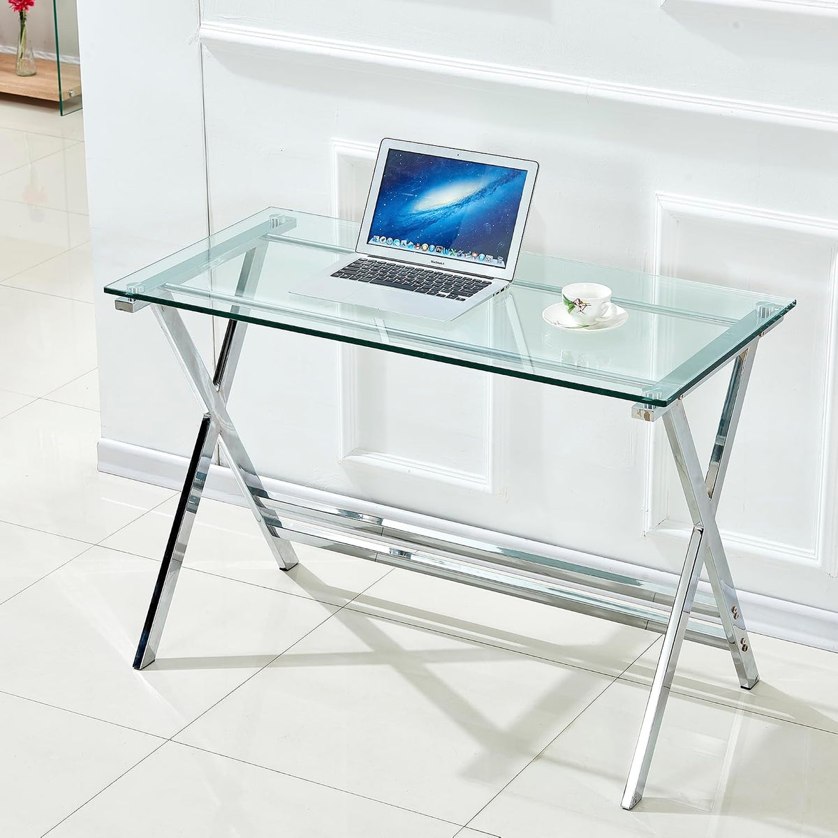 Front-right view of clear tempered glass desk with open laptop and teacup on top in a bright room
