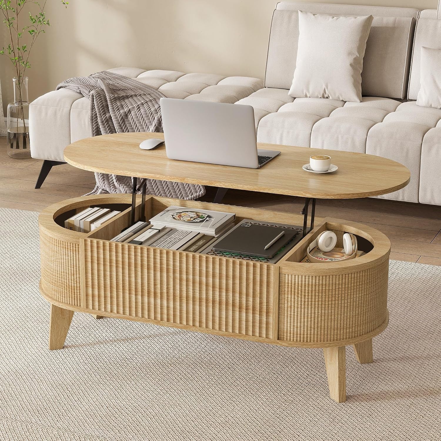 Oval walnut lift-top coffee table with top raised revealing divided storage, fluted exterior and four tapered legs, in front
