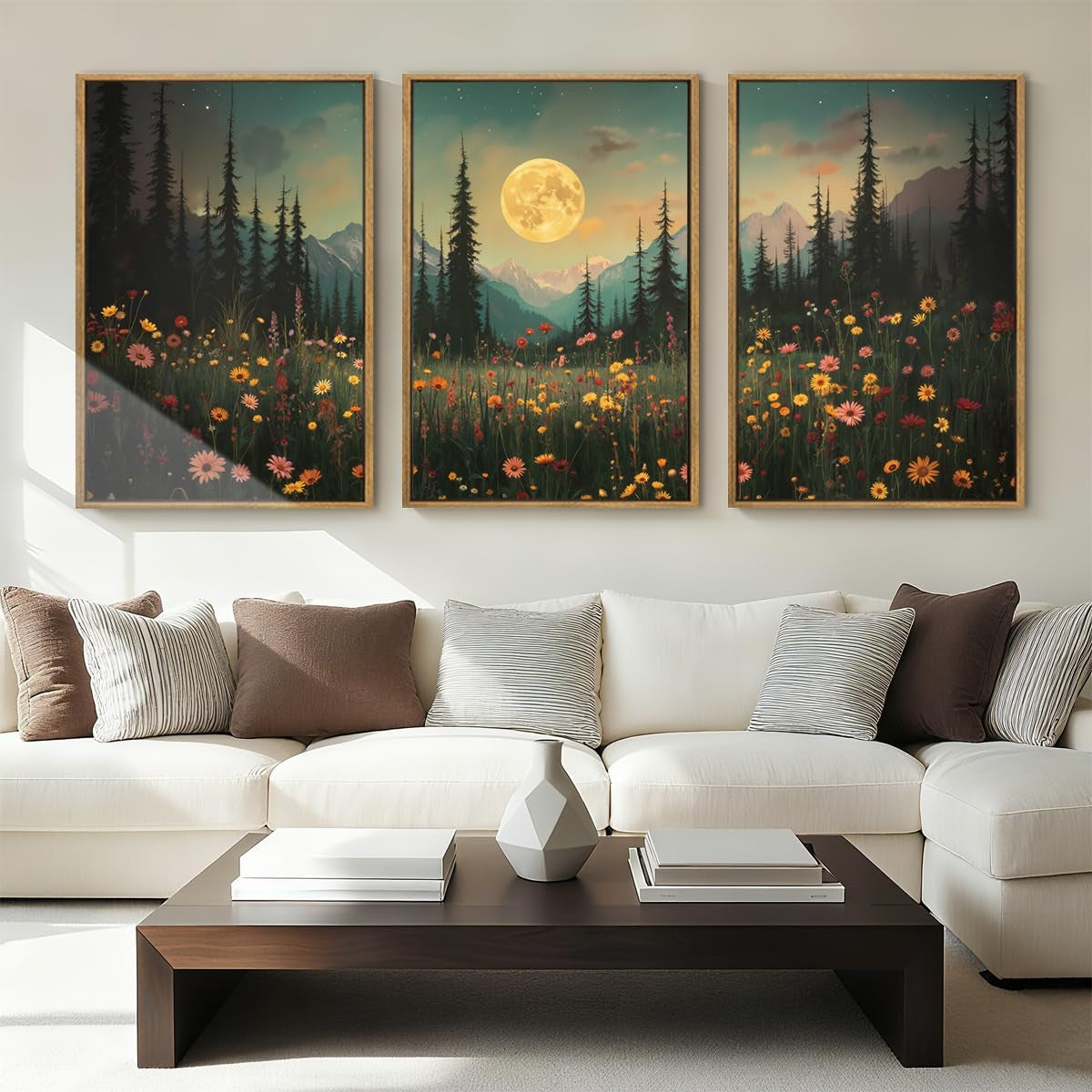 Three vertical framed prints above a white sofa: moonlit mountain scene with wildflowers and full moon center.