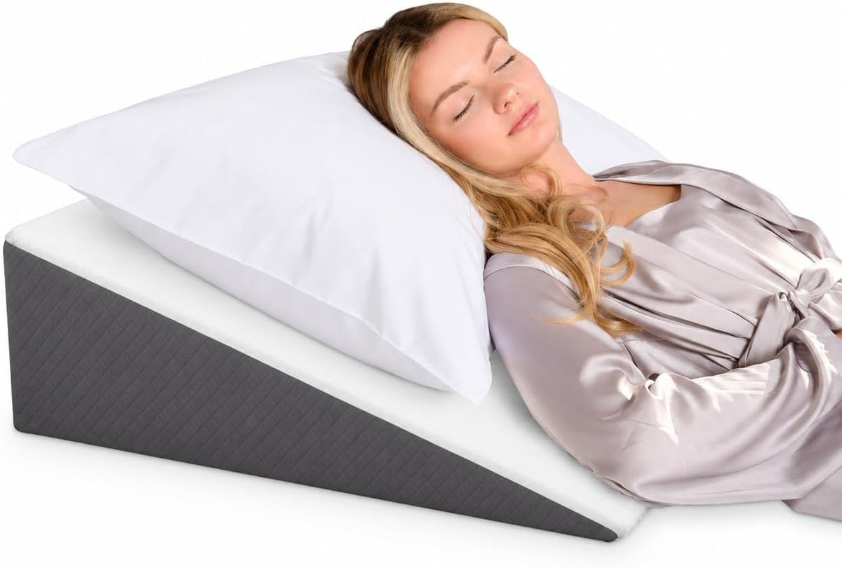 Zippered gray jacquard cover partially removed from a triangle wedge pillow on a blue background