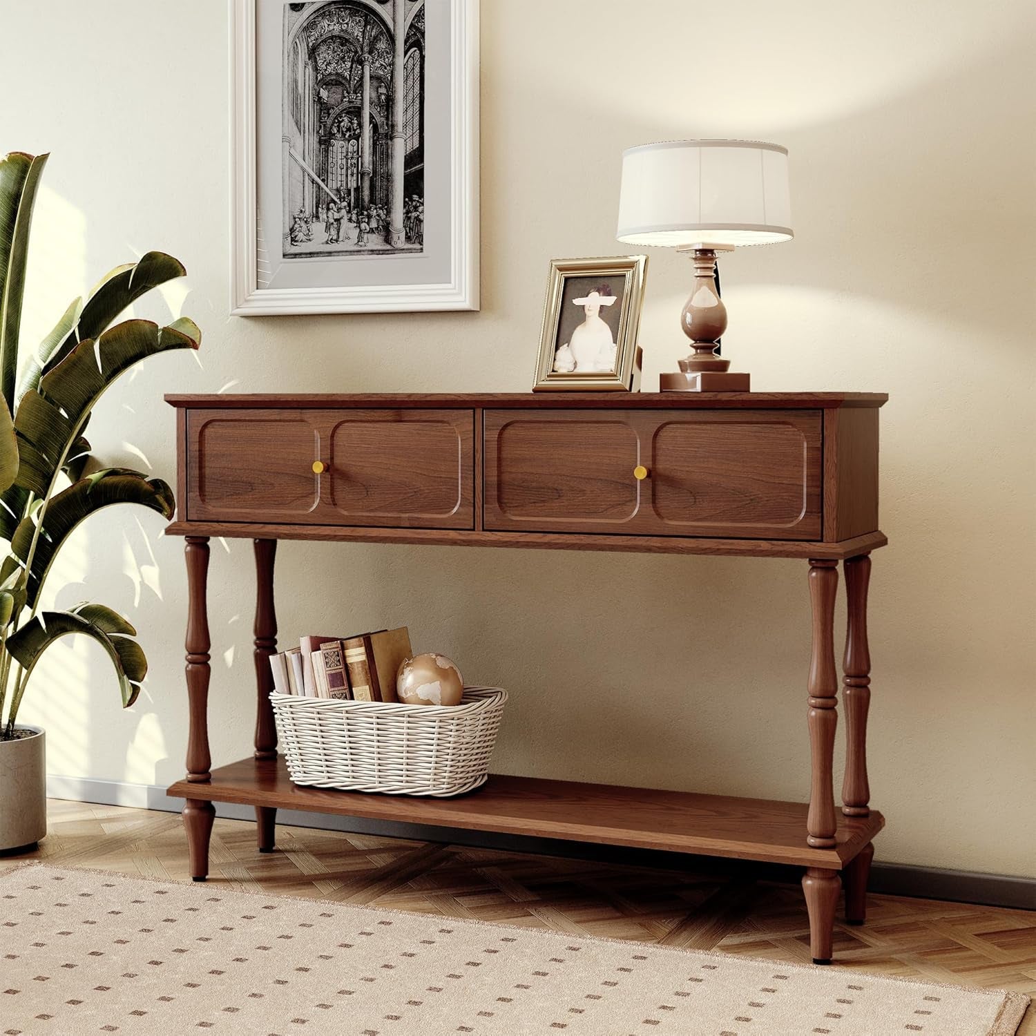Angled front view of brown console table styled in a living room with lamp and artwork
