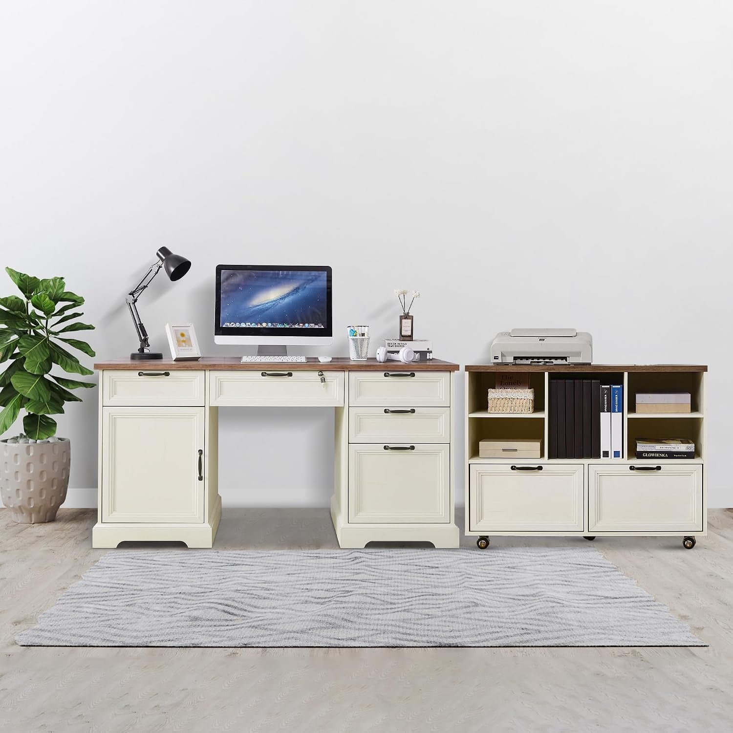 Cream-white L-shaped desk set shown front-on with wood top, potted plant at left and rug underfoot