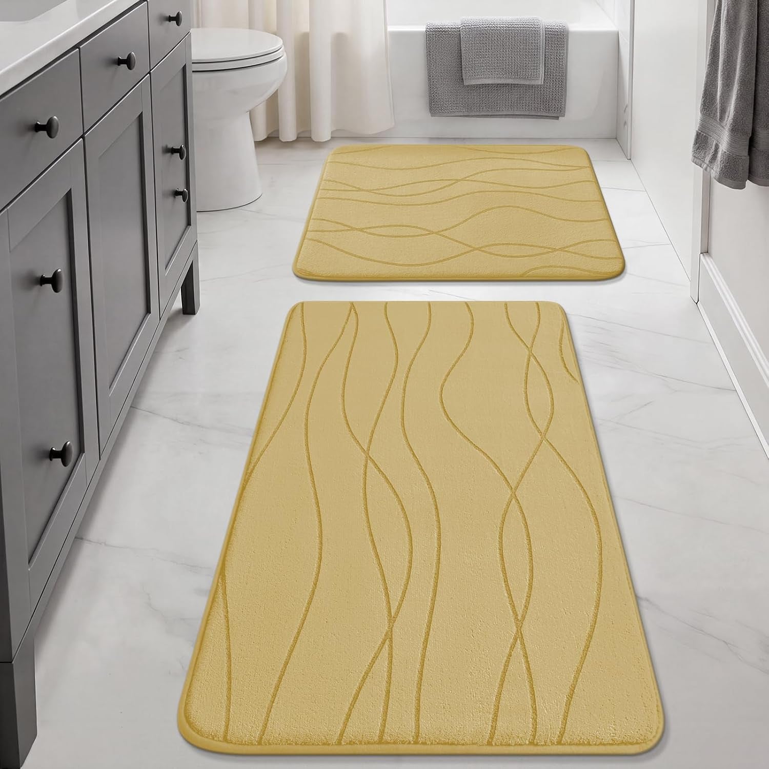 Bathroom view with a yellow runner in foreground and a matching square mat placed by the tub on white tile