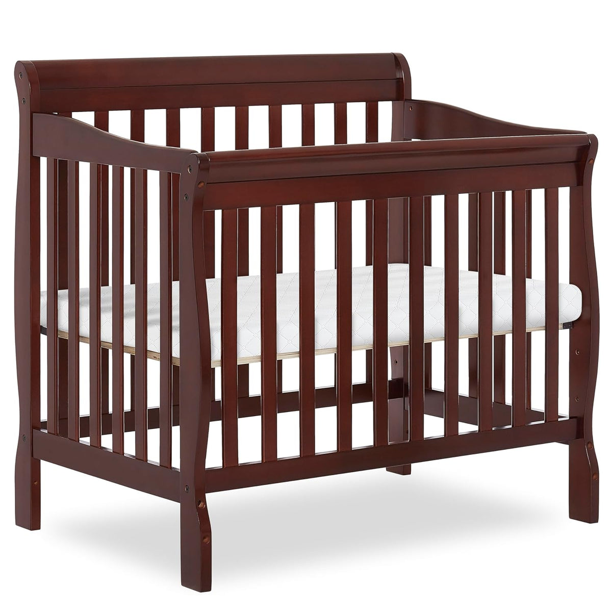 Dark brown wooden mini crib with slatted sides and a white mattress, shown on white background