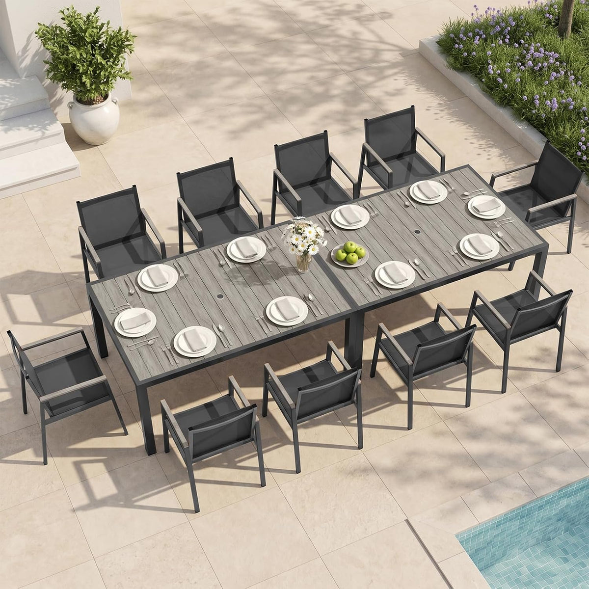 Overhead view of a large outdoor dining table with twelve black sling chairs arranged around it.