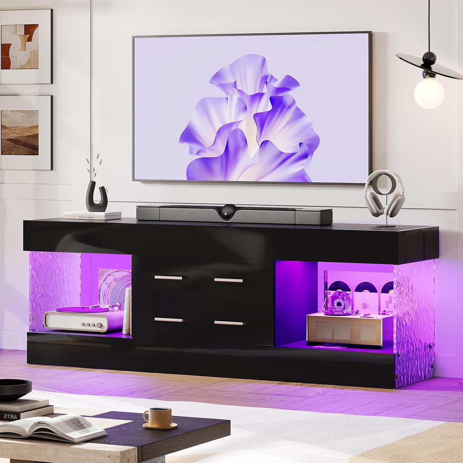 Black glossy TV stand with purple LED-lit open shelves, wall-mounted TV and headphones on stand