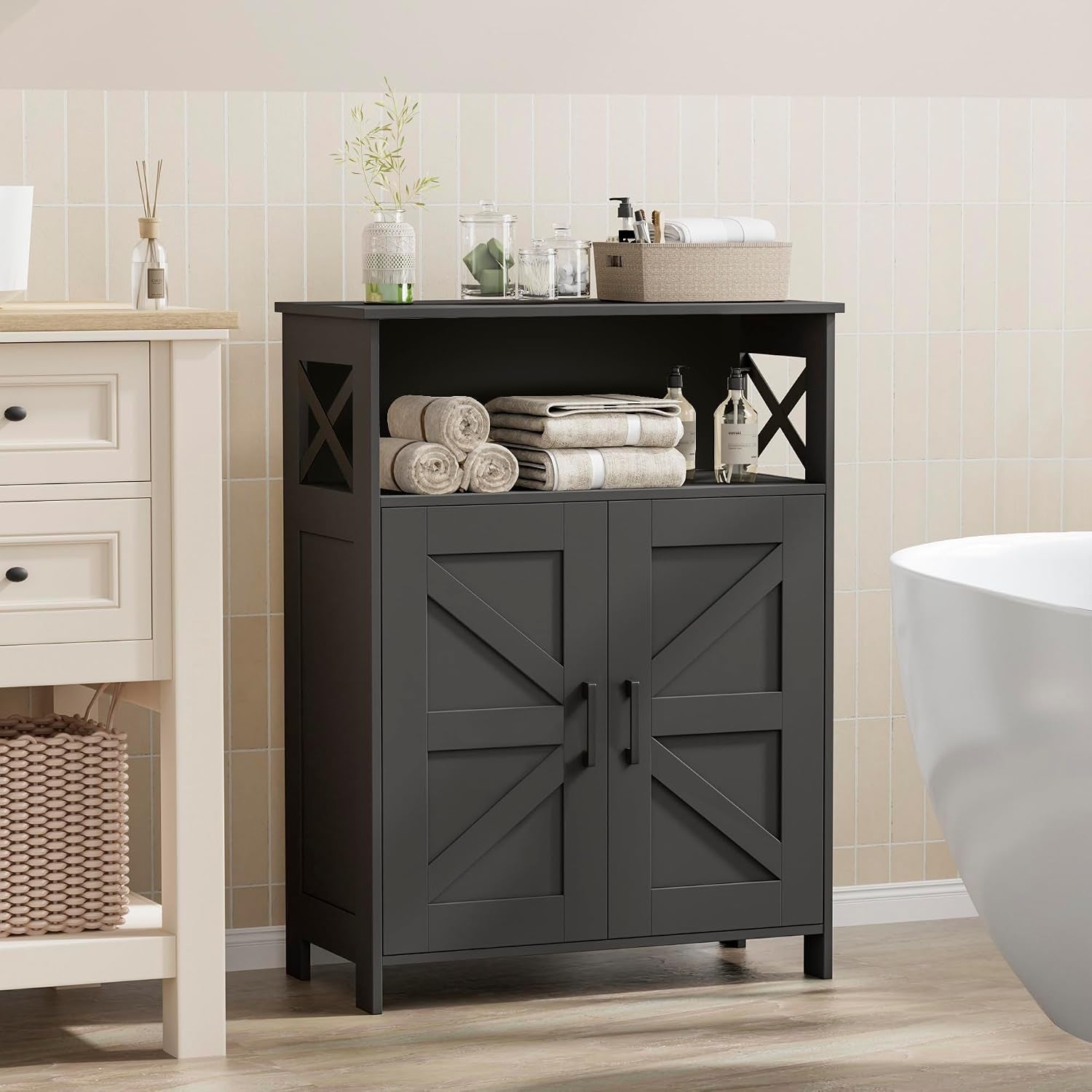 Freestanding black farmhouse bathroom cabinet with open shelf and double doors beside a sink and tub