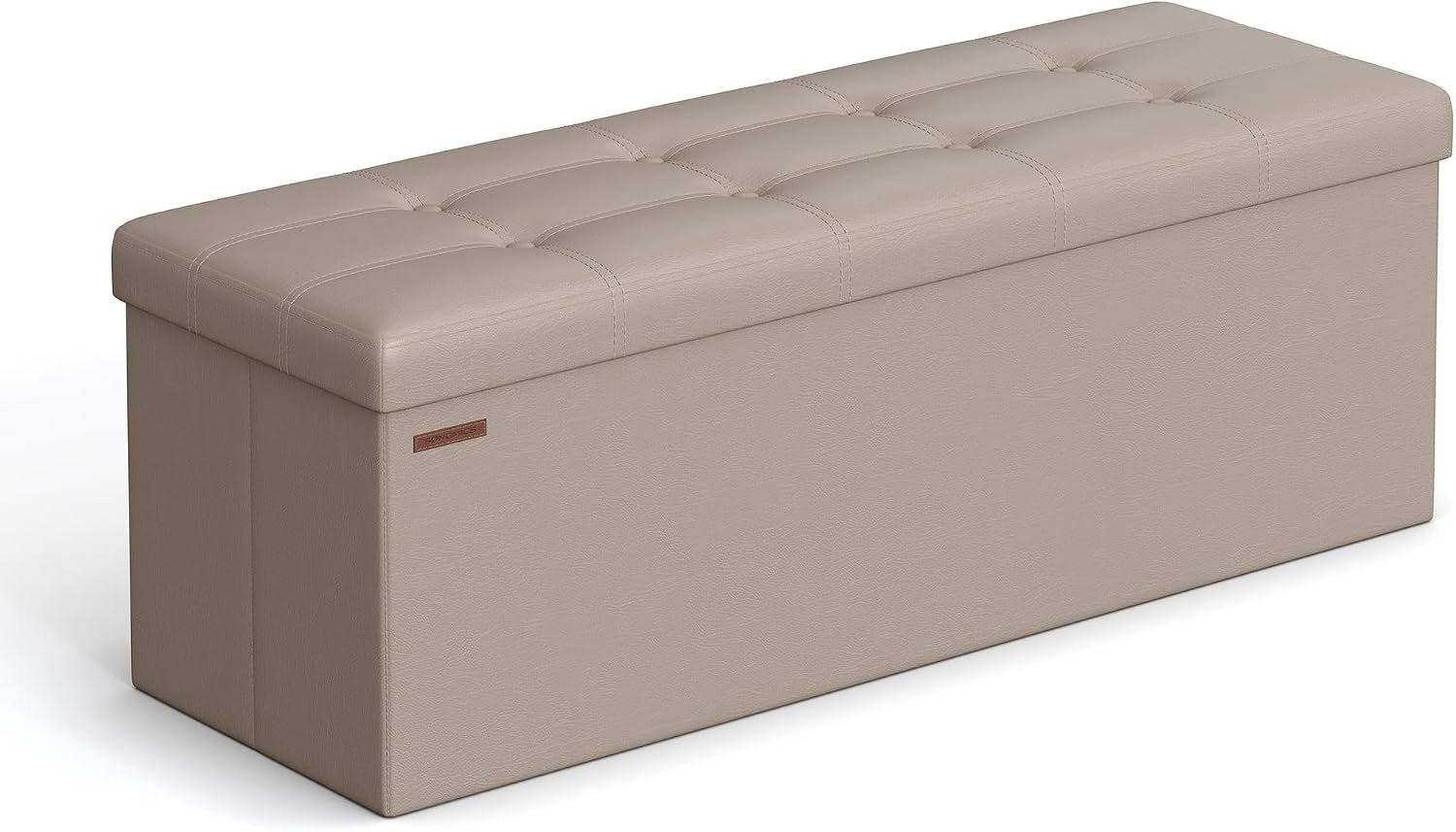 Beige/taupe tufted faux-leather folding storage bench shown at an angle with a small leather tag on the side.