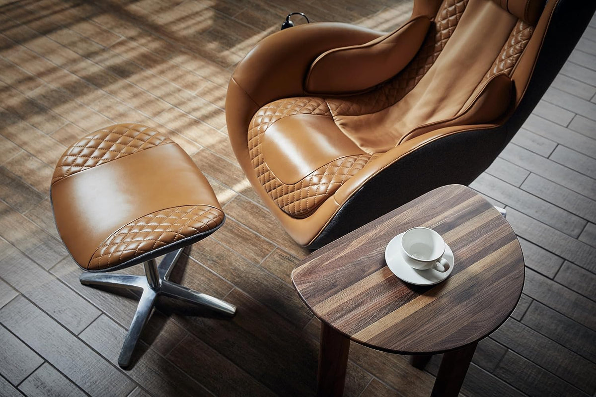 Caramel leather ottoman and chair set on wood floor beside a small wood side table holding a cup