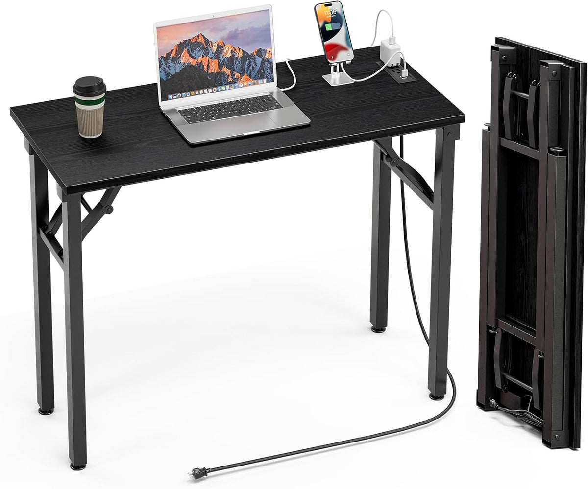 Three-quarter shot of black desk showing phone charging at integrated outlet and the desk folded upright at right.