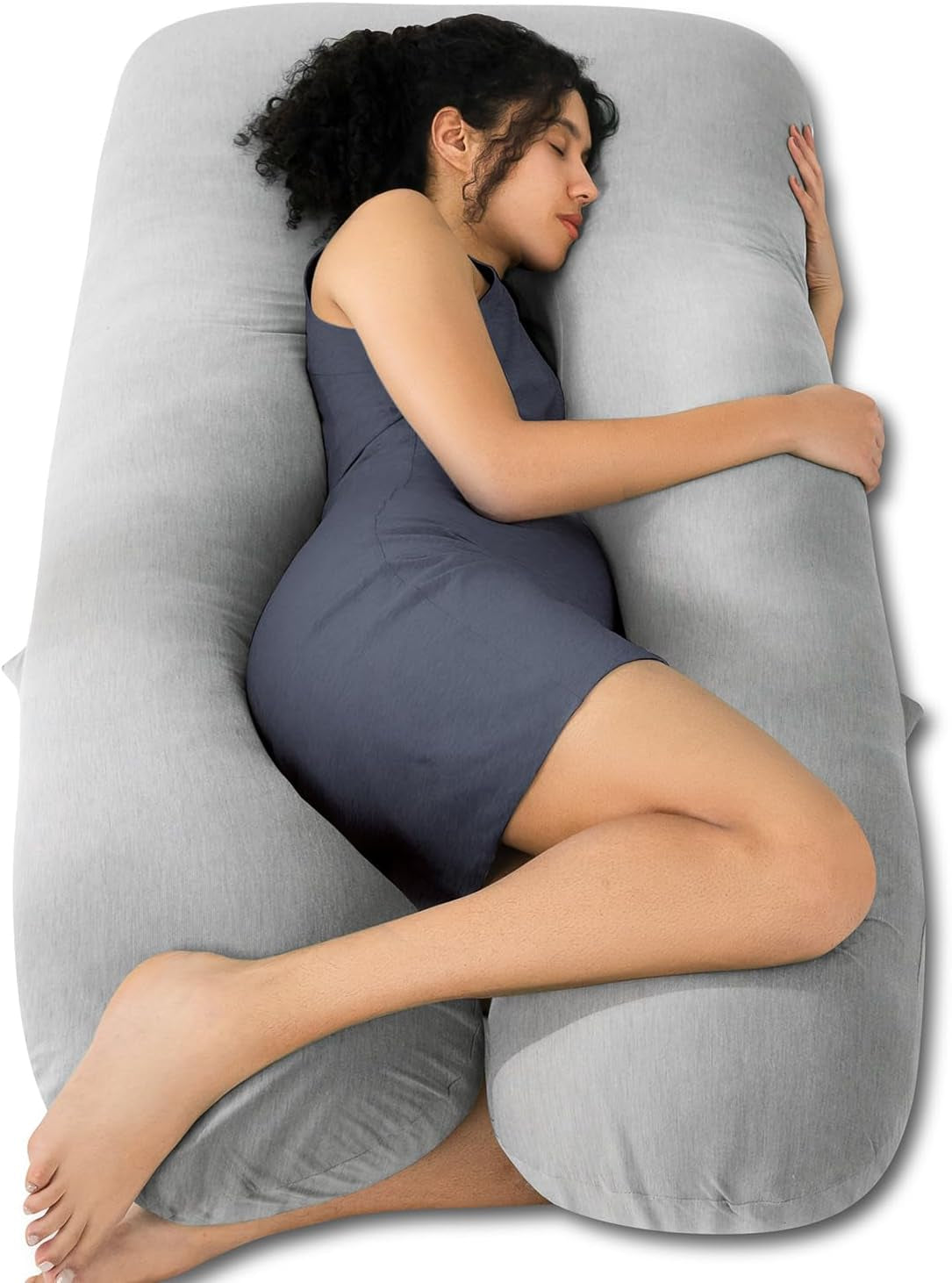 Overhead shot of a pregnant woman cuddling a light gray U-shaped maternity pillow while lying on her side.