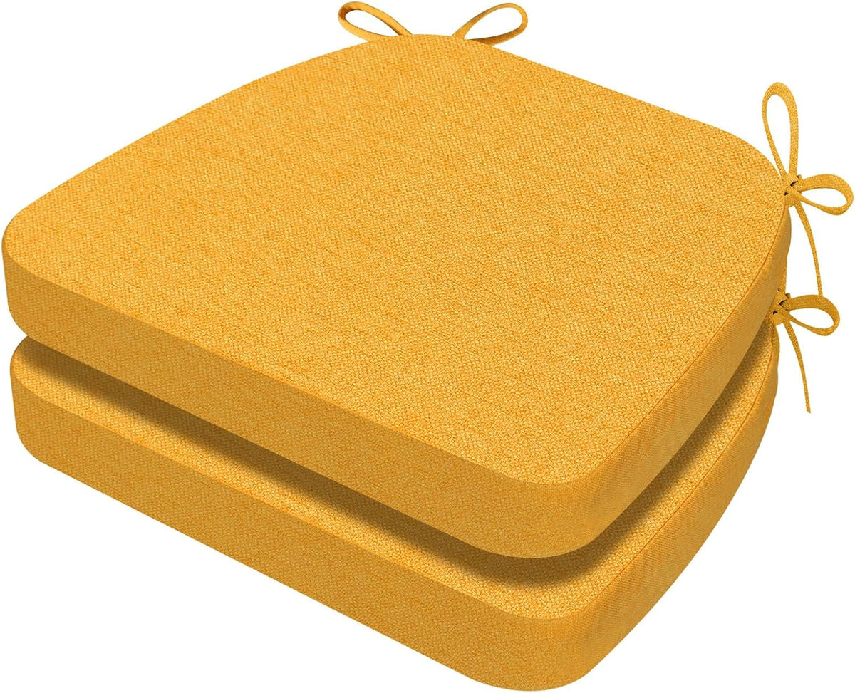 Angled close-up of two golden-yellow D-shaped chair cushions stacked, showing rounded front and tie loops