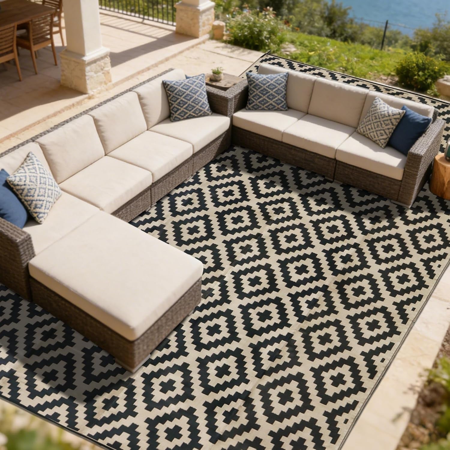 Overhead view of a large geometric outdoor rug anchoring an L-shaped sectional with neutral cushions