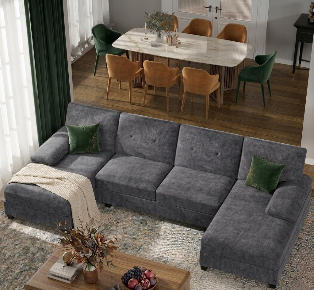 Slate gray U-shaped sectional with green accent pillows and a throw on the left chaise.