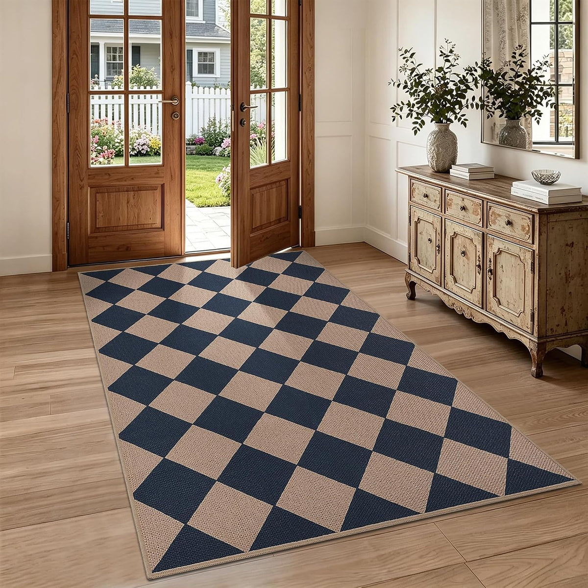 Long checker-pattern rug in navy and tan placed in a bright entryway beneath open wood doors.
