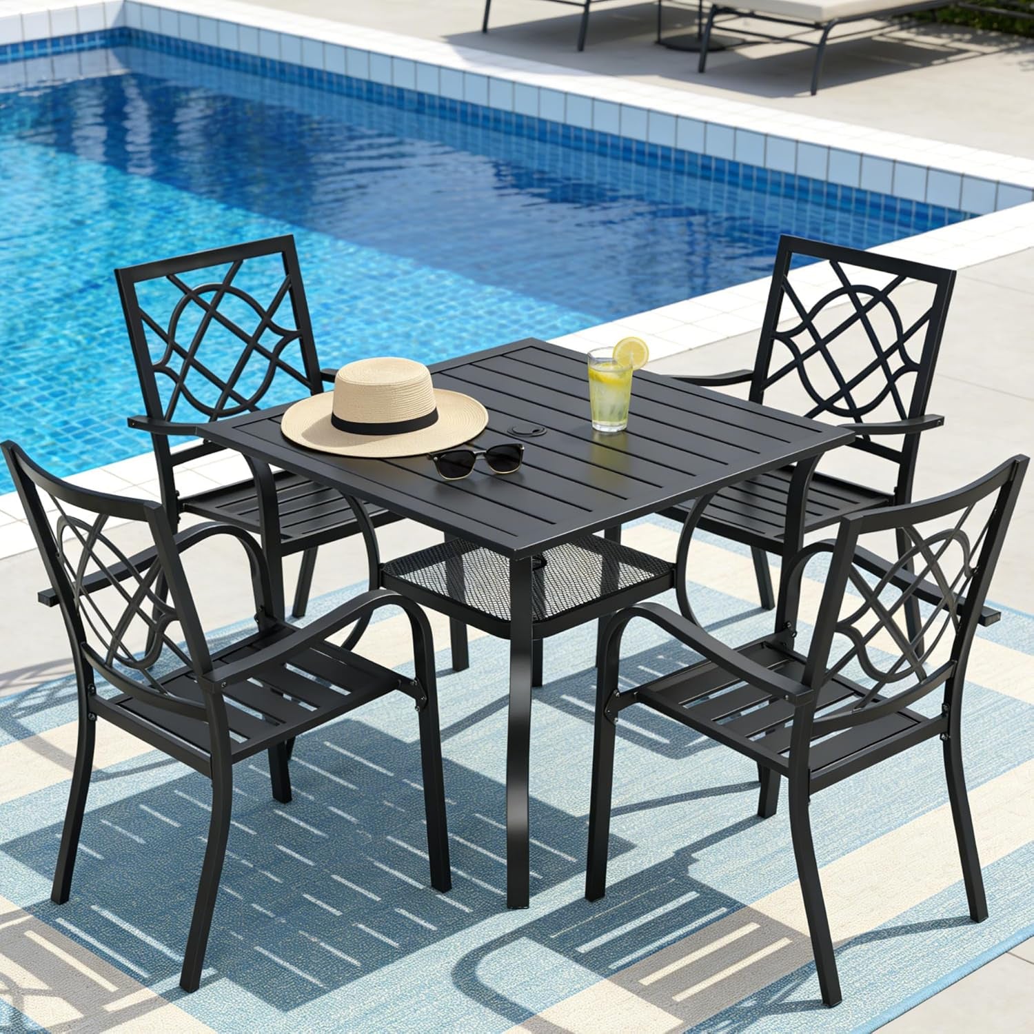 Black metal 5-piece patio dining set beside a pool with a hat and drink on the 37-inch square table.