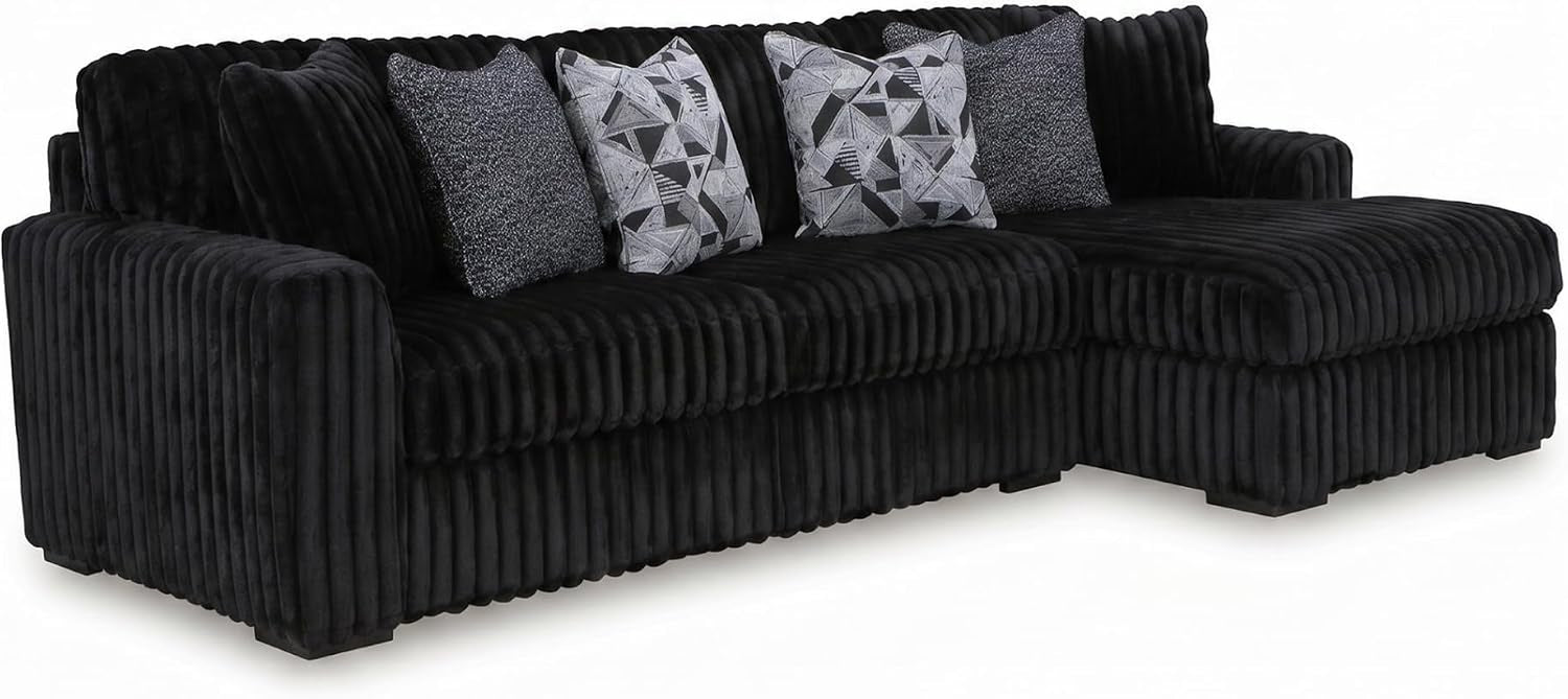 Black oversized corduroy chaise sectional with right chaise and patterned throw pillows