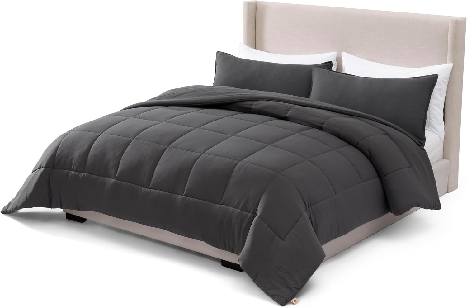 Front three‑quarter view of a dark grey comforter set with two rectangular shams on a neutral upholstered bed.