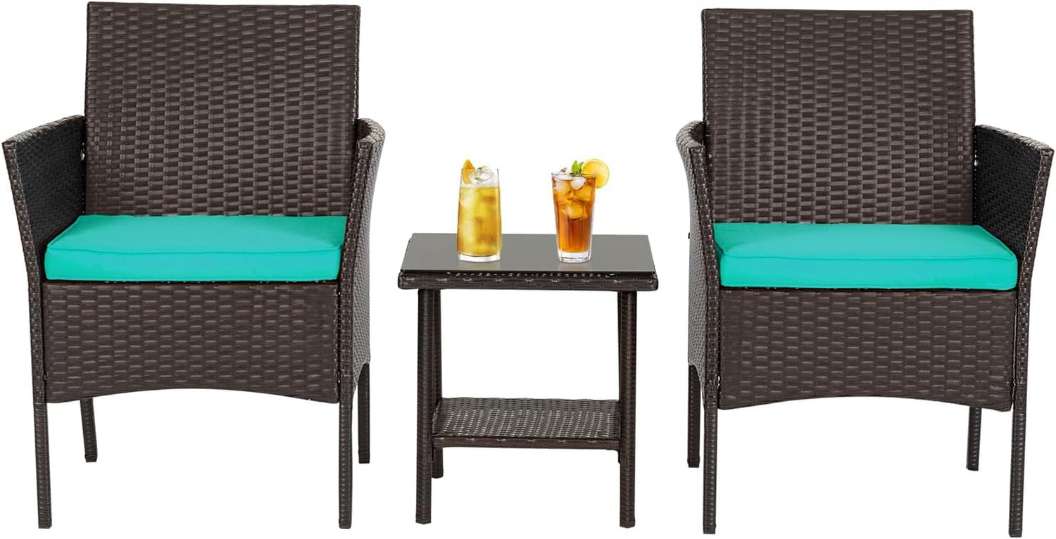 Two brown woven armchairs flanking a small glass-top rattan side table, teal seat cushions and two iced drinks on table