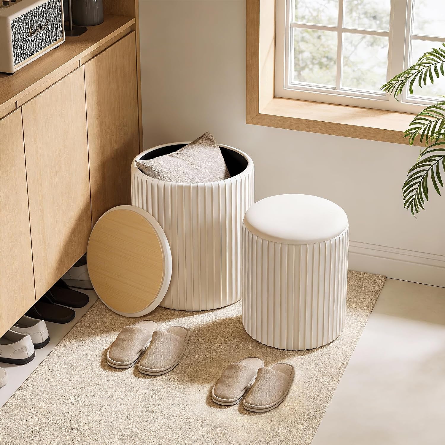 Beige ottoman set placed in an entryway with large ottoman open showing storage interior