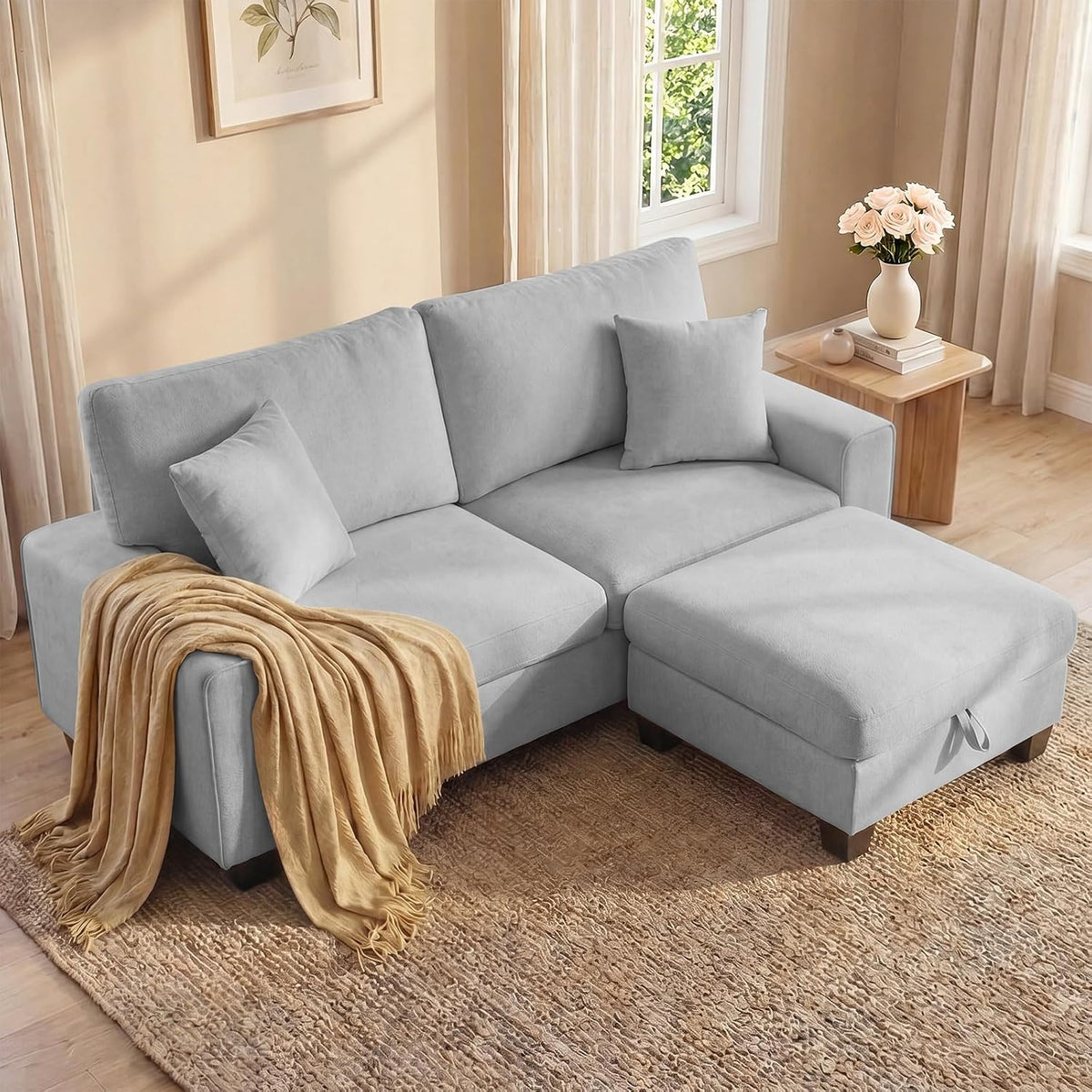 Light gray chenille loveseat with ottoman pulled forward and a tan throw draped over the arm