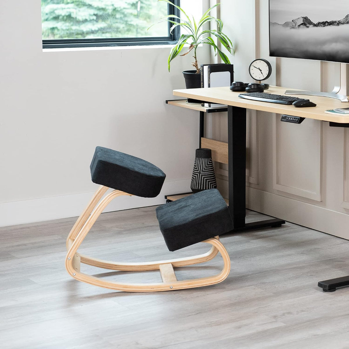 Isolated ergonomic rocking kneeling chair with light wood curved frame and two black upholstered pads