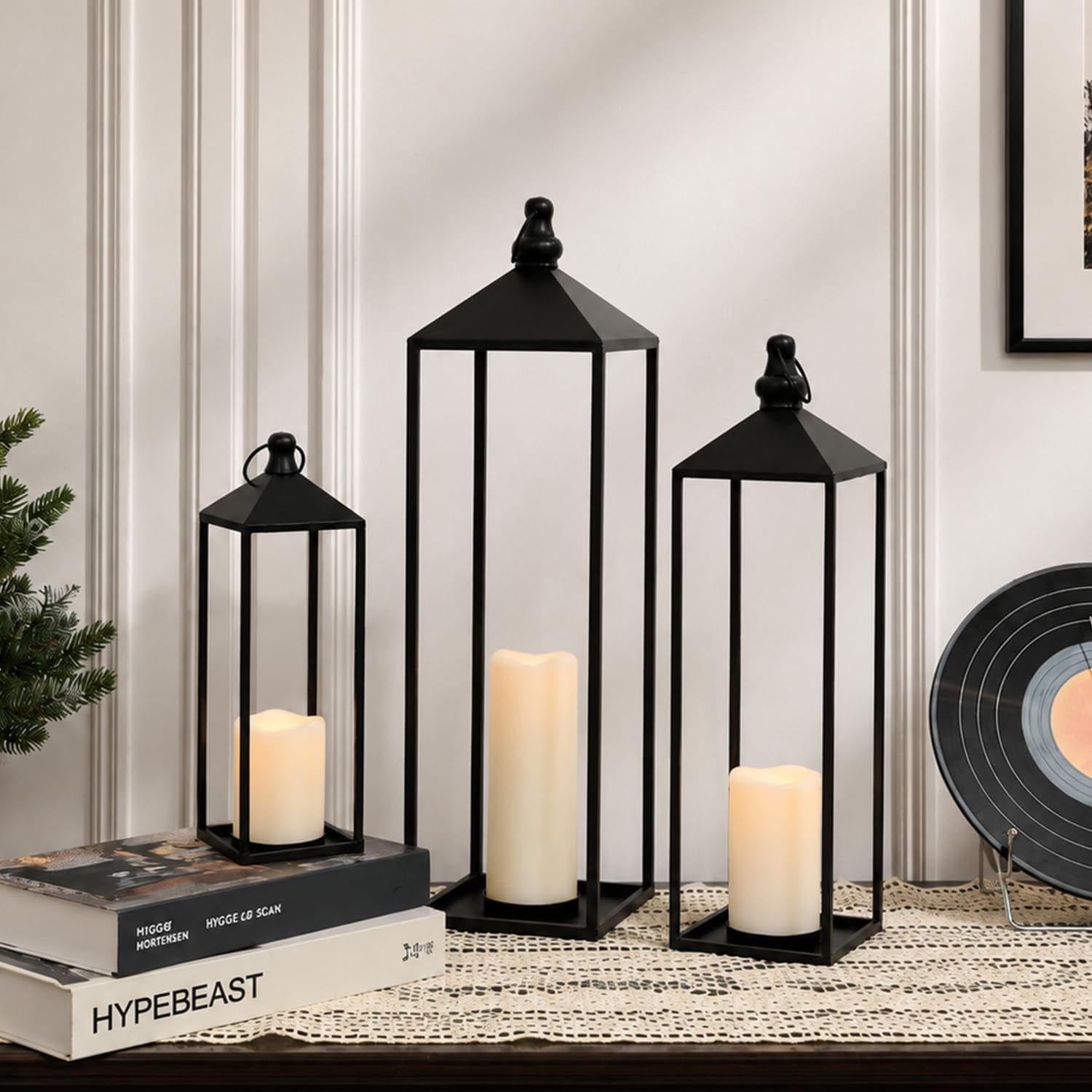 Black metal lantern trio with LED flameless candles on a table, angled front view in a living room setting
