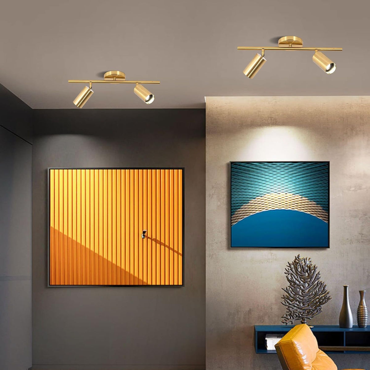 Two gold 2-light track fixtures on a living-room ceiling above a console, with orange and blue abstract wall art.