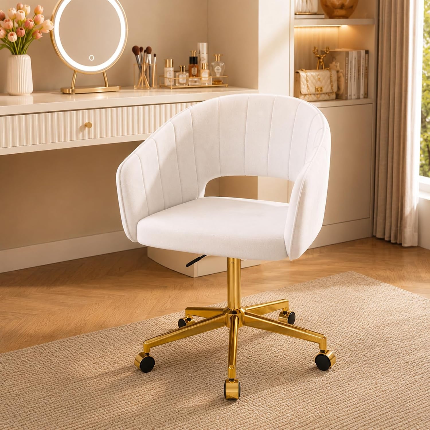 Pearl white velvet swivel accent chair with gold metal base shown angled front in a vanity setting