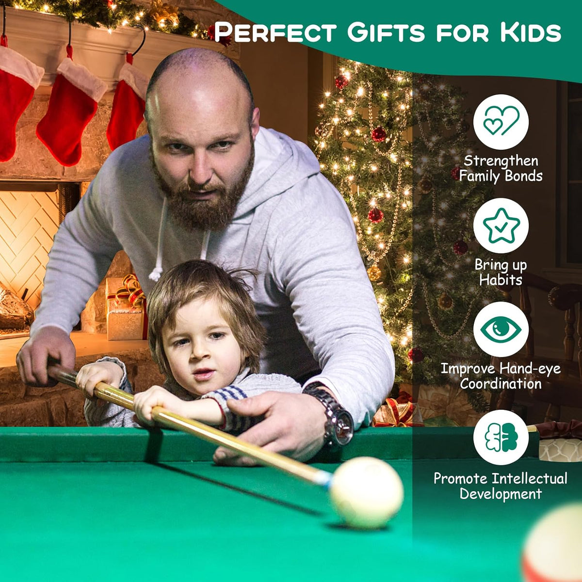 Adult guiding a small child as the child aims a cue over the green felt of the table by a decorated fireplace.