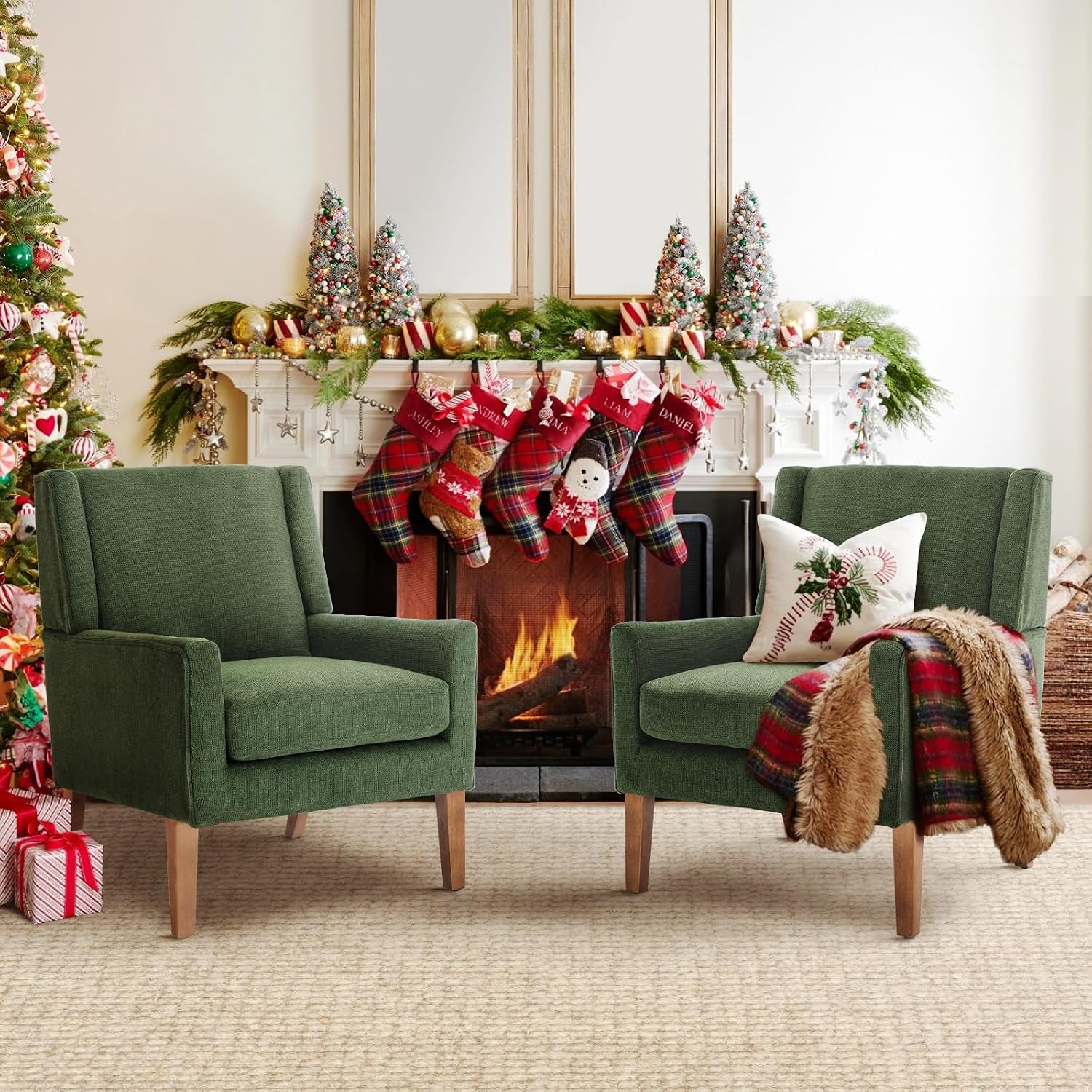 Two green wingback chairs arranged in front of a decorated fireplace with stockings