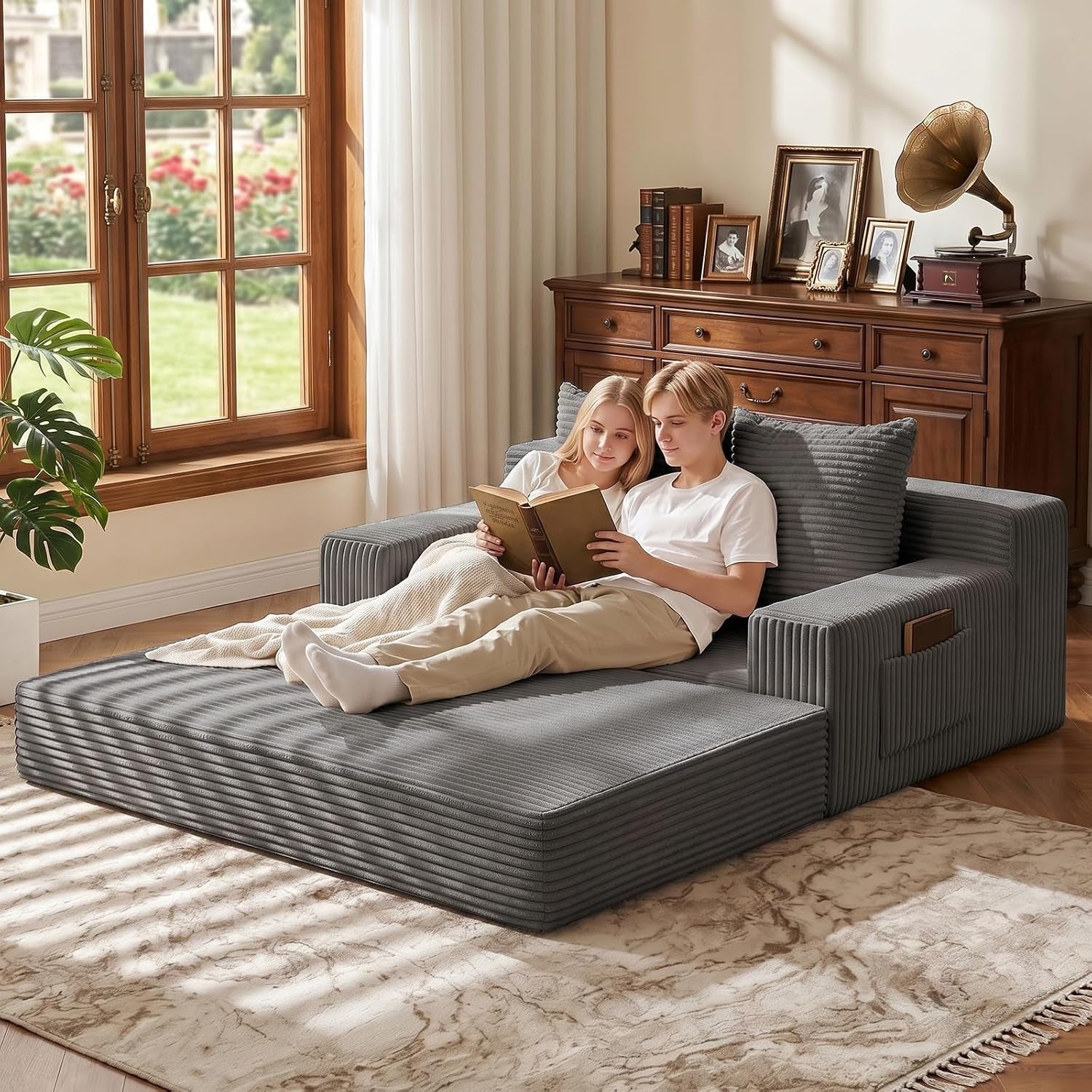 Grey loveseat shown converted to a flat sofa bed with extended mattress section and armrest side pocket visible