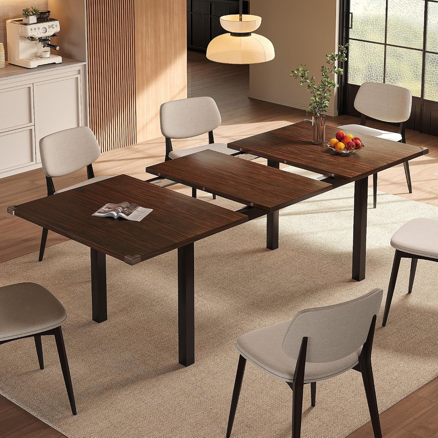 Dining table partially extended showing center leaf and seating for six in a warm wood finish.