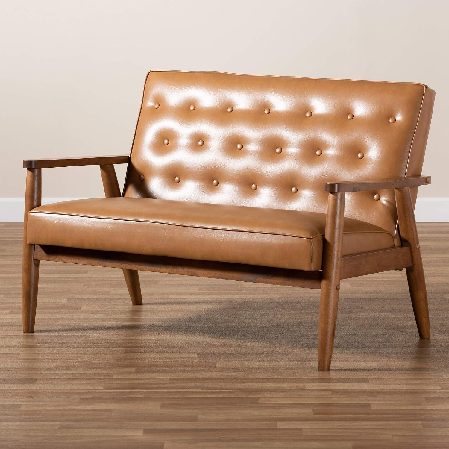 Low-angle three-quarter view highlighting the loveseat's front apron and exposed wooden support under the seat