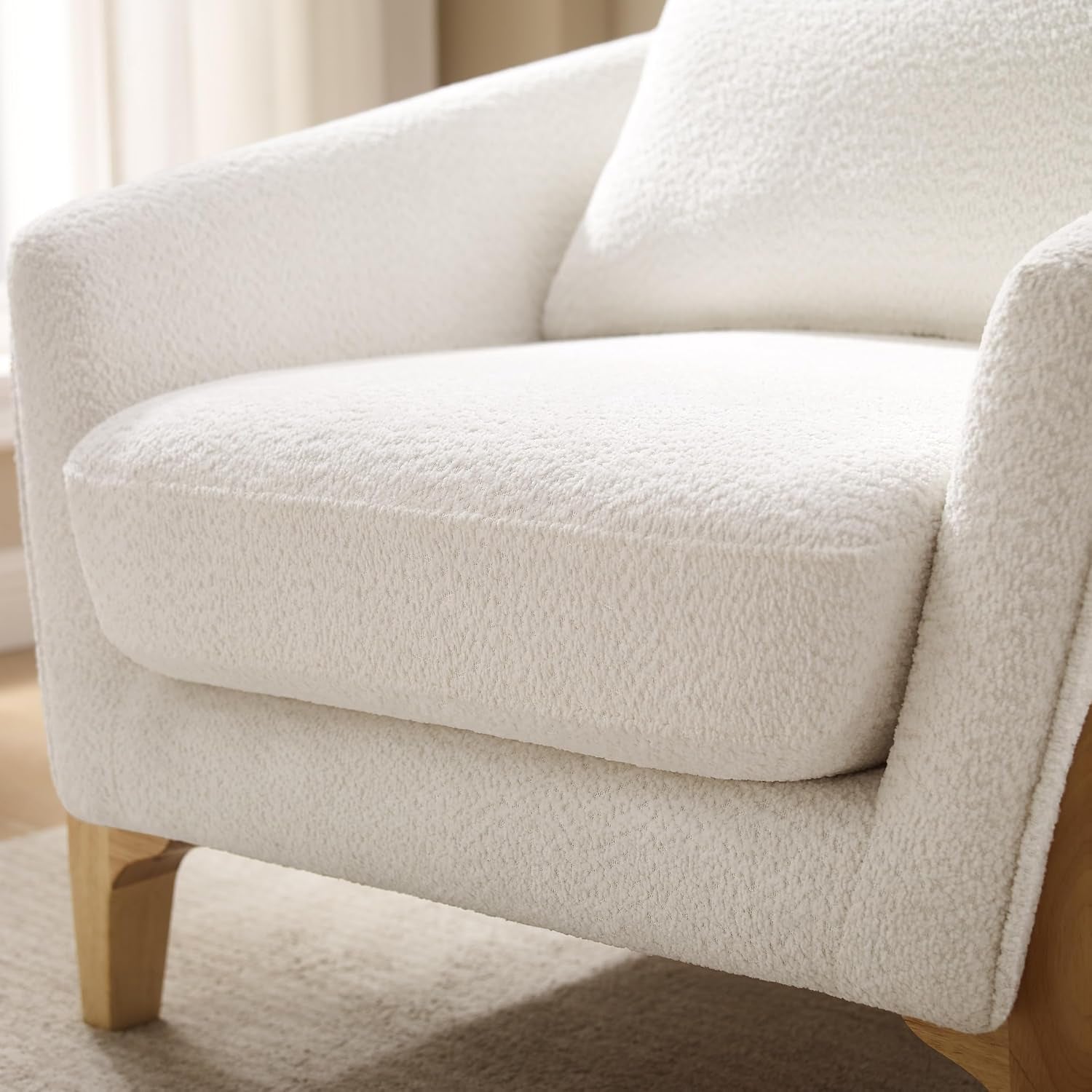 Tight detail of the seat cushion and front arm covered in white fleece fabric